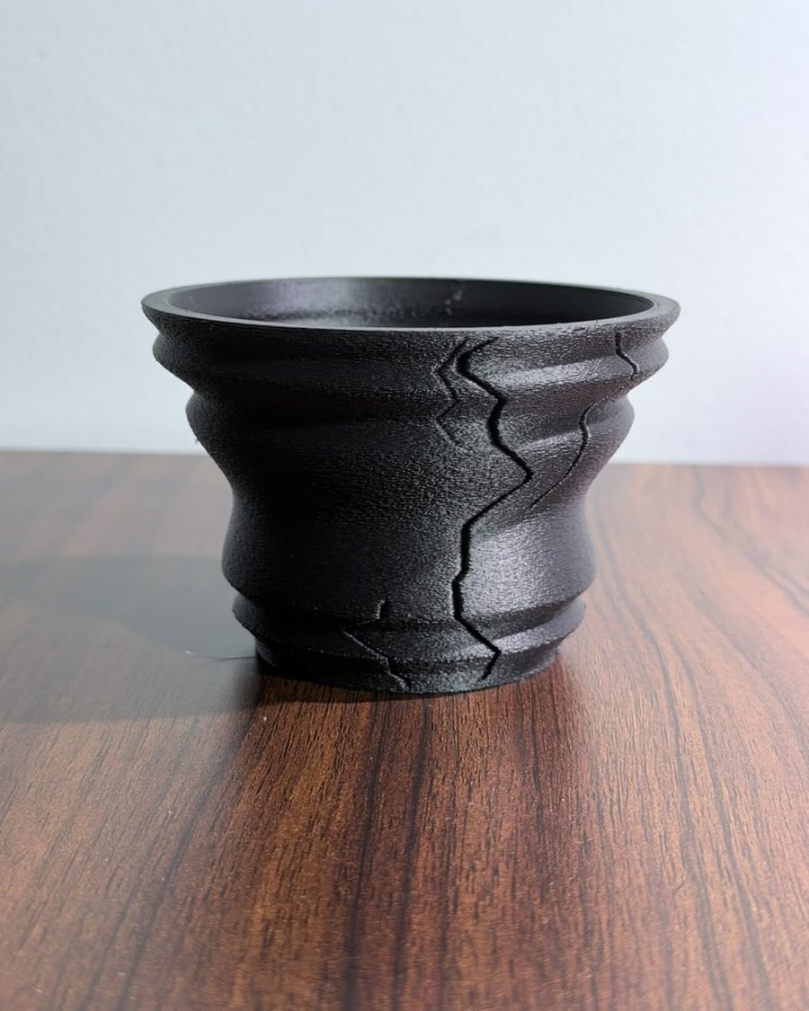 Matte black 3D-printed planter with a cracked stone surface