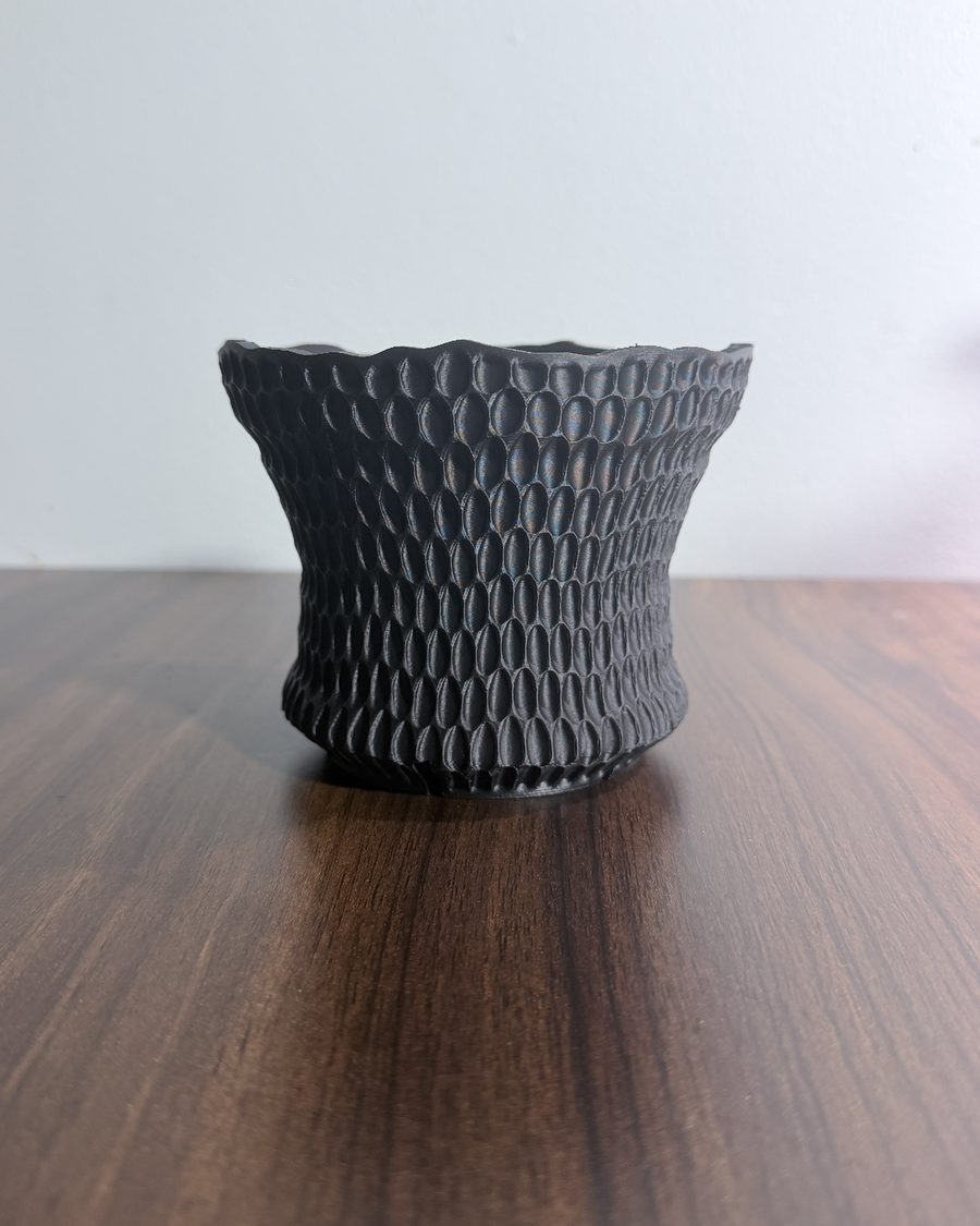 Black 3D-printed planter covered in small honeycomb cells